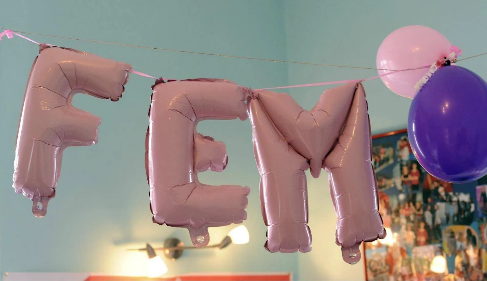 Rosafarbene Folienballons bilden das Wort FEM
